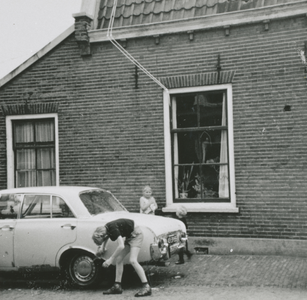 863384 Afbeelding van enkele kinderen die een personenauto aan het poetsen zijn in de Jan Meijenstraat in Wijk C te Utrecht.